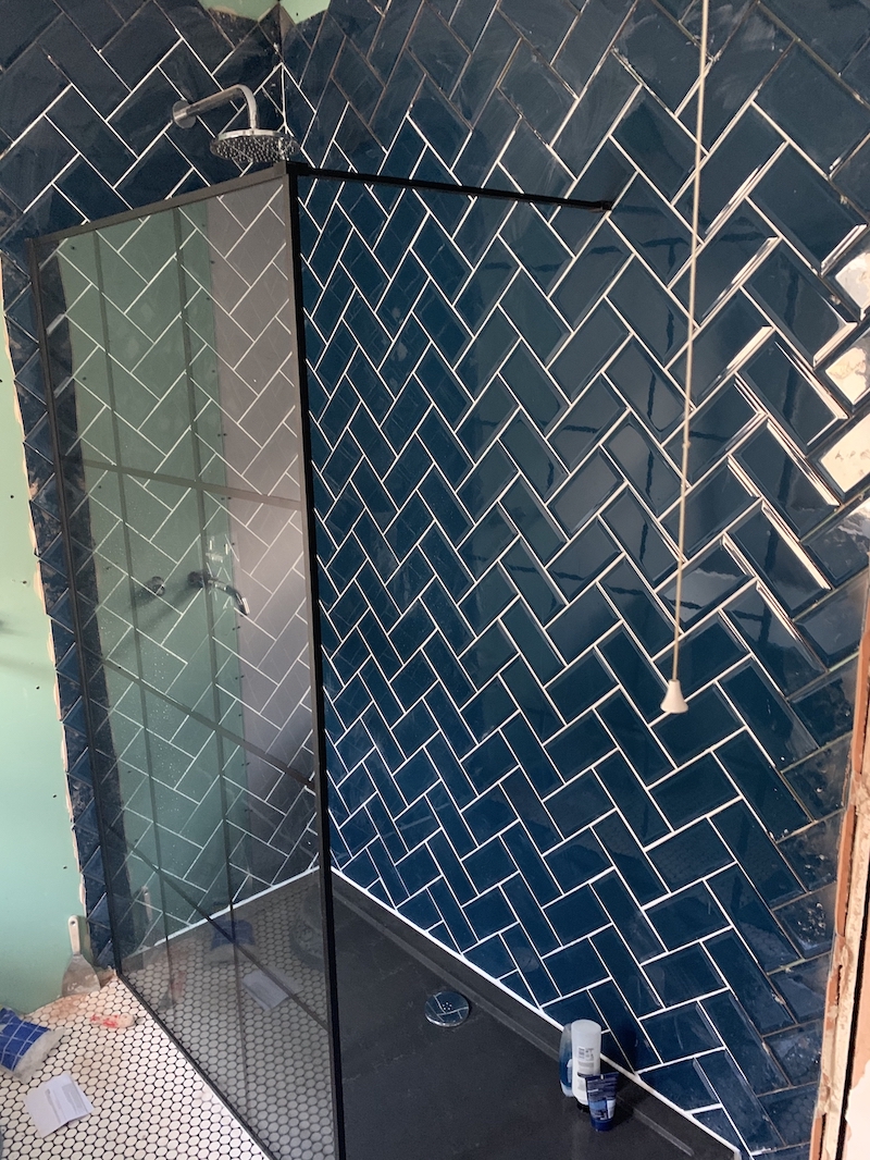 The new shower tray and glass with grouted tiles