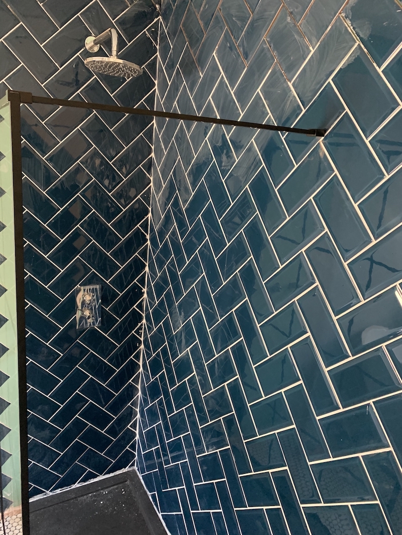 The new shower tray and glass with grouted tiles